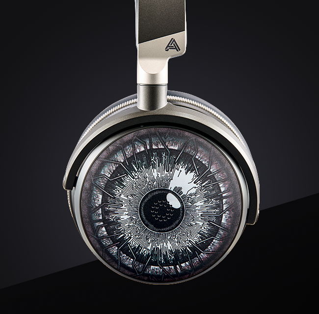 Silver over-ear headphones with a unique eye graphic design on the ear cup, featuring a sleek, modern style.