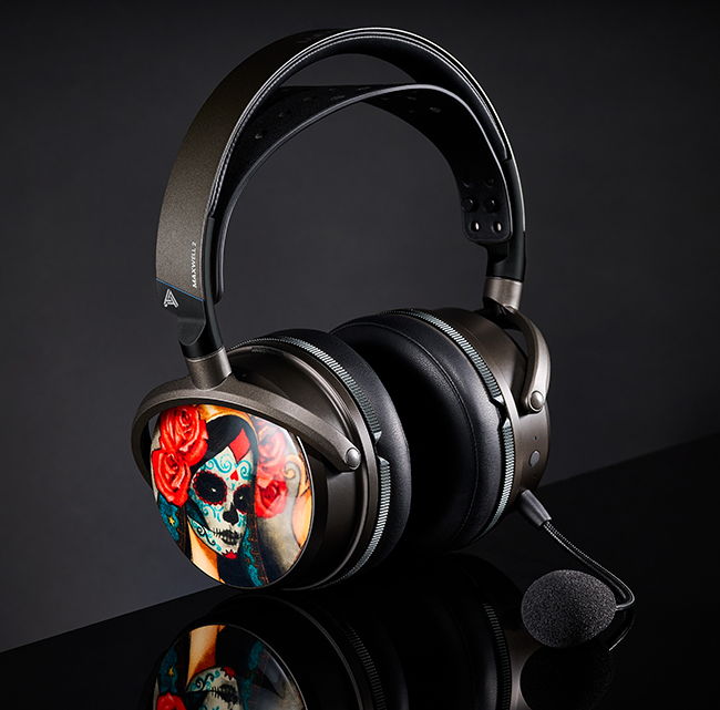 Black over-ear headphones with a decorative sugar skull and rose design, featuring a detachable microphone.